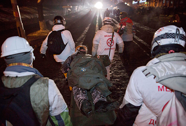 Медики транспортируют раненого демонстранта