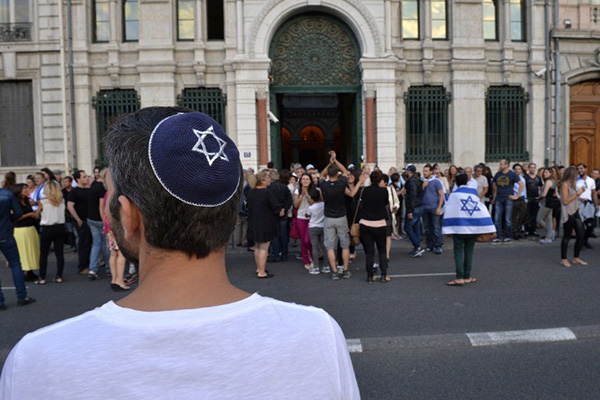  A man wearing a skullcap looks on as people take part in a demonstration called by the Representative Council of Jewish Institutions in France (CRIF) on July 31, 2014 in front of Lyon's synagogue, as France is considering disbanding a radical Jewish group, the Jewish Defence League (LDJ), whose members clashed with pro-Palestinian activists during rallies over Israel's offensive in Gaza. The rally is in response to weeks of pro-Palestinian protests marred by clashes, arrests and allegations of anti-Semitism in which synagogues were targeted and Israeli flags burnt