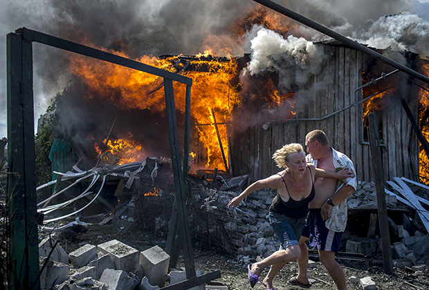 Местные жители спасаются от пожара, возникшего в результате авиационного удара вооруженных сил Украины по станице Луганская.
      
      