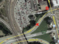 Место, где находилась машина Кеннеди в момент первого выстрела, обозначено крестиком. Место, где находился снайпер, обведено кружком. Фрагмент спутникового снимка Google Maps. Кликните на картинке, чтобы увидеть ее же, но большего размера.