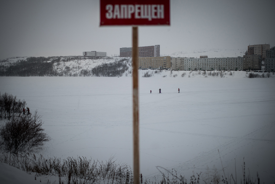 Перед озером стоит знак, запрещающий ходить по льду.