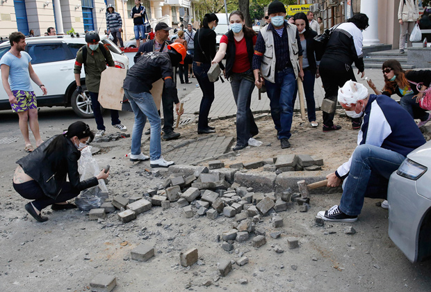 Люди готовят булыжники в качестве боеприпасов во время столкновений 2 мая 2014 года в Одессе