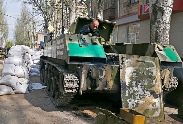 Боец ополчения ремонтирует бронетранспортер на улице Славянска