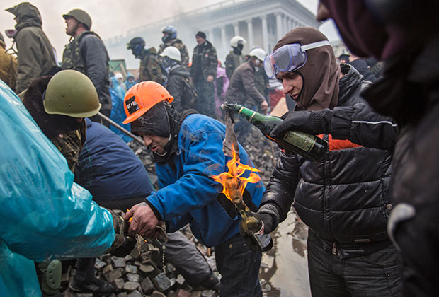 Сторонники оппозиции поджигают бутылки с зажигательной смесью на Майдане Независимости в Киеве, где начались столкновения митингующих и сотрудников милиции. 