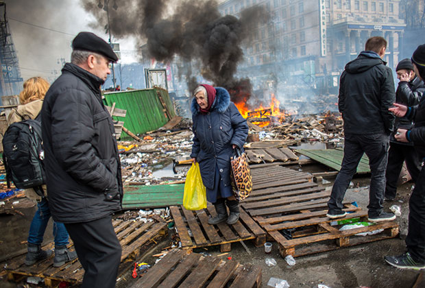 Пожилая женщина и сторонники оппозиции на Майдане Независимости в Киеве, где начались столкновения митингующих и сотрудников милиции.