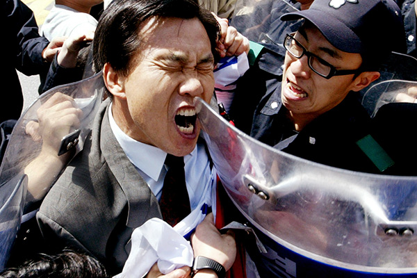 Полиция задерживает протестующего перед японским культурным центром в Сеуле. 22 апреля 2005