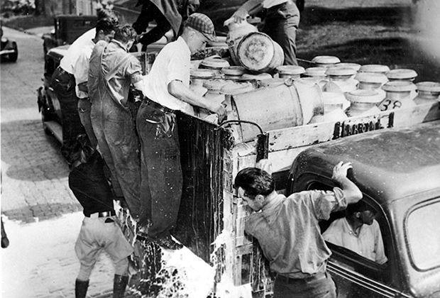 Забастовка фермеров во время Великой депрессии. Фермеры выливают молоко на тротуар.