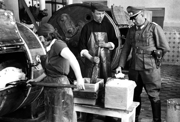 Немецкий офицер проверяет качество масла на украинской молочной ферме, 1942 год