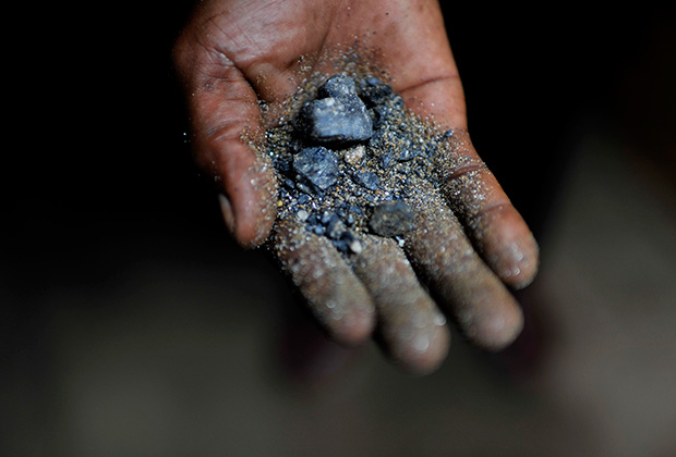 Шахтер из Демократической Республики Конго держит в руке минерал колтан