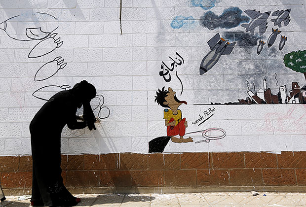 Сторонники хоуситов рисуют граффити на стене посольства Саудовской Аравии в Сане