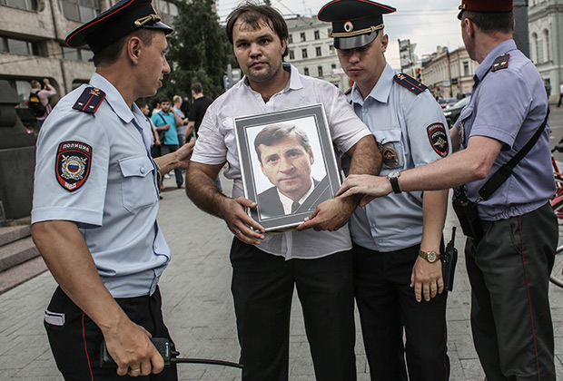  Лидер движения «Россия молодая» Антон Демидов (в центре) с портретом мэра Нефтеюганска Владимира Петухова