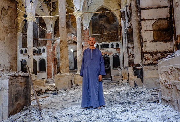 Копт в одной из сожженных и разрушенных коптских церквей в провинции Минья, 2013 год