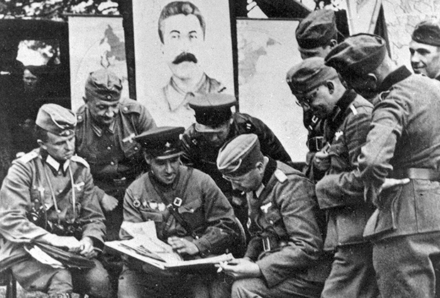 Немецкие военные беседуют с командиром советского танкового полка под Брестом.  1939 год