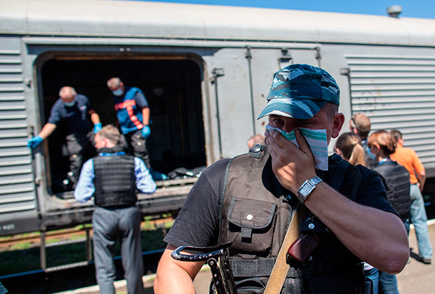 Сотрудники миссии ОБСЕ и эксперты из Нидерландов осматривают вагон с телами погибших в авиакатастрофе