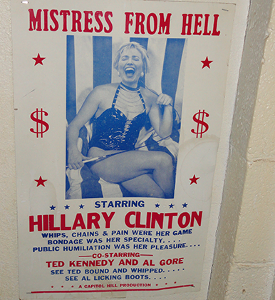 Надпись на плакате с Хиллари Клинтон в баре в Сан-Диего: «Госпожа ада. Связывание — ее специализация. Хлысты, цепи, боль — ее игра. Публичное унижение — ее удовольствие»