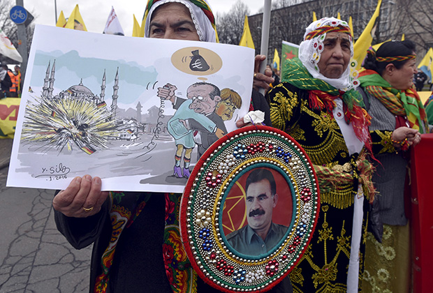 Прокурдская демонстрация в Ганновере. В руках участницы карикатура, изображающая Эрдогана и Меркель, а также портрет лидера РПК Оджалана. 19 марта 2016 года