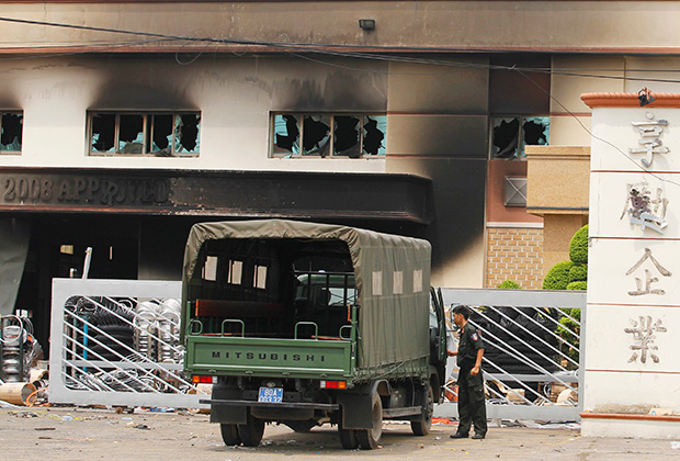 Полицейские возле здания компании, разгромленной во время антикитайских выступлений. 16 мая 2014