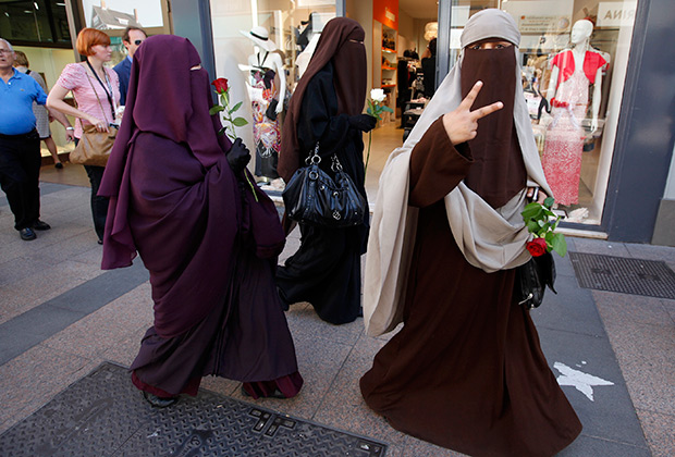 Три женщины идут на демонстрацию против запрета паранджи во Франции, 17 мая 2011 года