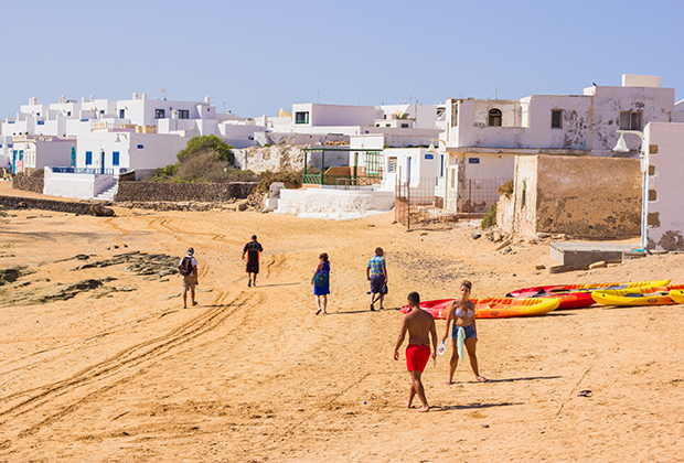 На пляже у пристани туристы и местные жители играют в волейбол