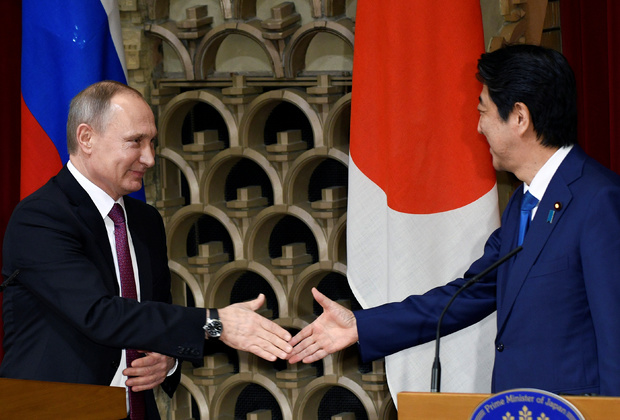 Владимир Путин и Синдзо Абэ пожимают руки в конце совместной пресс-конференции