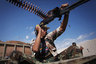 A revolutionary fighter fires at Gadhafi loyalists in downtown Sirte, Libya, Tuesday, Oct. 18, 2011. About 1,000 Libyan revolutionary troops have launched a major assault on Moammar Gadhafi's hometown, surging from the east to try to capture the last area under loyalist control.  