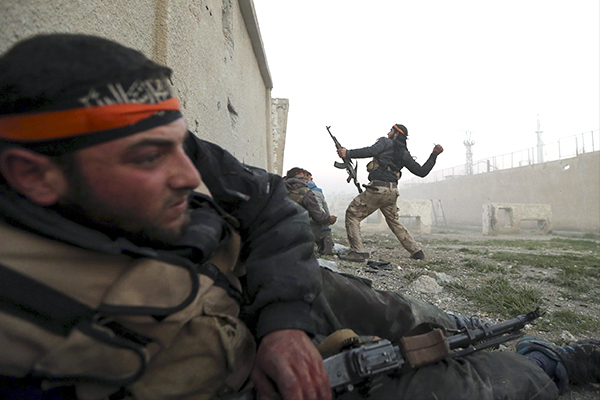 A Free Syrian Army throws a hand grenade during an attack on a Syrian Army base