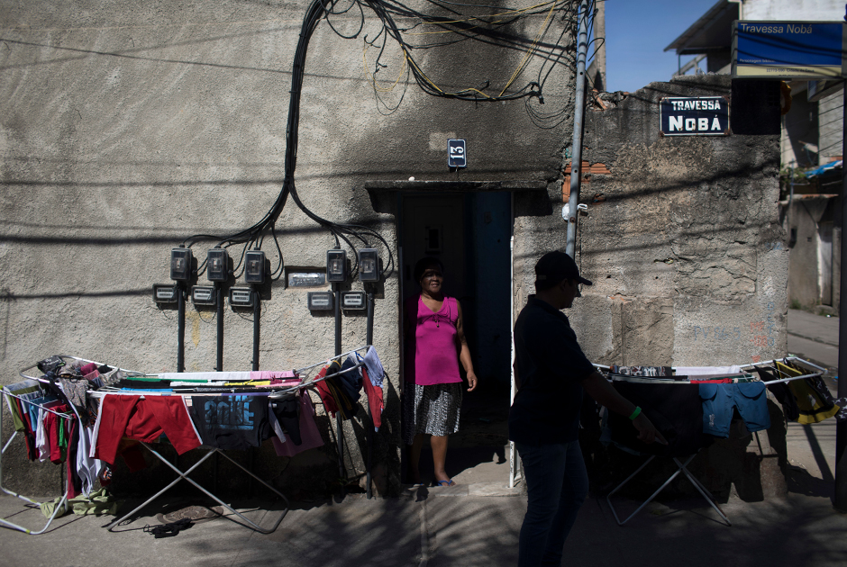 Местный пастор, бывший наркоторговец Сильвио Сесар Соарес Гонзага идет по улице «Божьего города». «Рио погрузился в хаос. Его отравило насилие», — рассказал он AP.