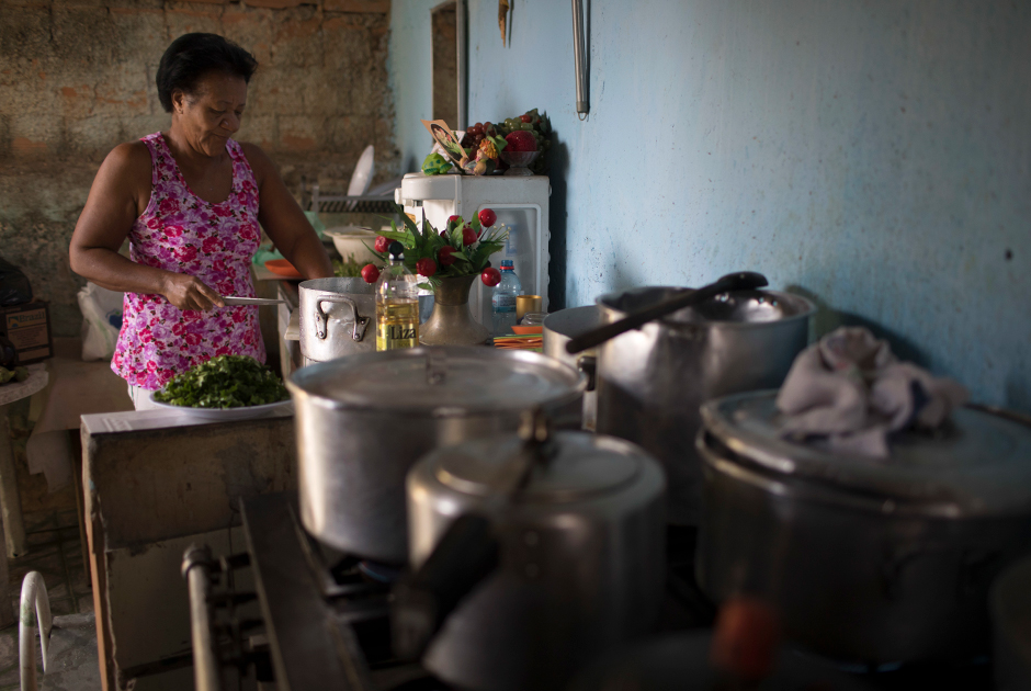 Анна Регина де Хесус готовит у себя на кухне: четыре дня в неделю она угощает обедами нуждающихся соседей.