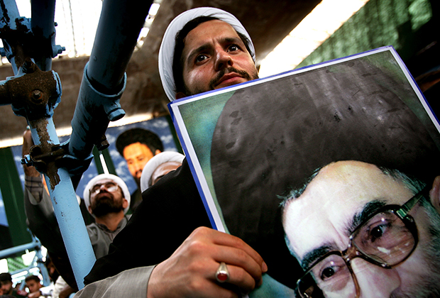 Иранский богослов с портретом Хаменеи в руках
