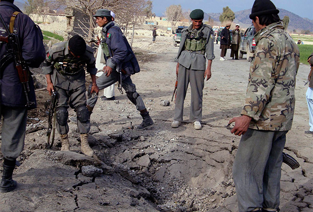 Афганские полицейские осматривают место нападения на американский патруль в провинции Хост
