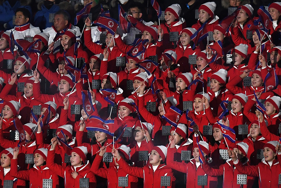 На трибунах спортсменов приветствуют болельщики сборной КНДР. Впервые в церемонии приняла участие объединенная команда КНДР и Южной Кореи. Они прошли под флагом корейского полуострова. 