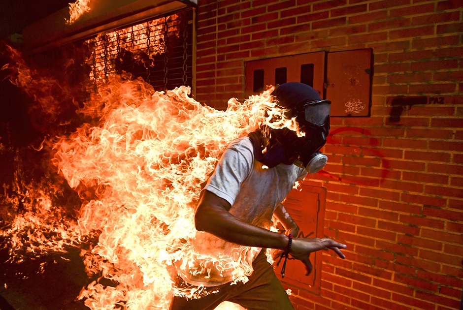 Протесты в столице Венесуэлы, Каракасе, против президента страны Николаса Мадуро переросли в ожесточенные столкновения. На фото — 28-летний протестующий бежит от местного ОМОНа.
