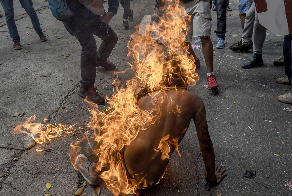 В ходе протестов против президента Венесуэлы Николаса Мадуро в Каракасе загорелся демонстрант. Рядом с ним взорвался бензобак полицейского мотоцикла. 