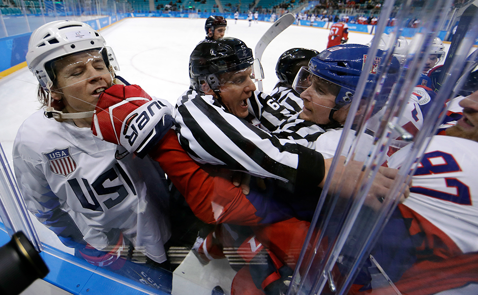 Рефери активно препятствует торжеству олимпийского духа в исполнении чешских и американских хоккеистов во время матча группового этапа Олимпиады. 