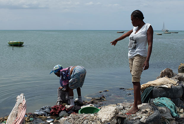 Женщины занимаются стиркой практически на помойке, в которую превращено побережье в городской черте