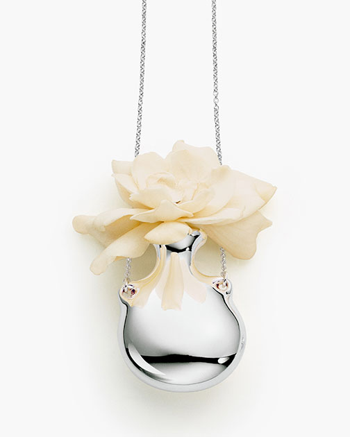 Самый весенний вариант подвески от дизайнера Эльзы Перетти: в полированную серебряную бутылочку неправильной формы, напоминающей гальку, можно, как в бутоньерку, опустить живой цветочный бутон. 