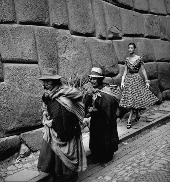 Фотомодель идет следом за местными жительницами по улице в Перу.