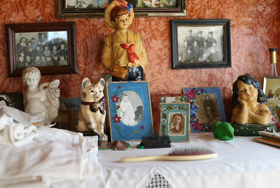Интерьер деревянного дома в деревне в Архангельской области: статуэтки, фотографии предков и родственников. 