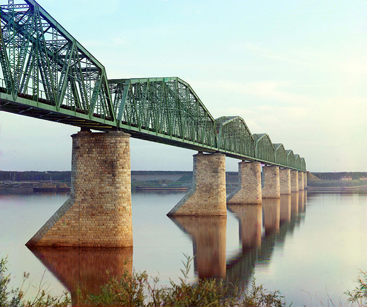 Строительство первого железнодорожного моста через Каму началось под Пермью в 1897 году и длилось два года. Мост состоял из десяти пролетов, сборка ферм производилась в мастерских Березина методом горячей клепки. Все фермы были сделаны из сварочного железа, изготовленного на Воткинском заводе. Металлические части моста весили более 254 тысяч пудов (4160 тонн). 