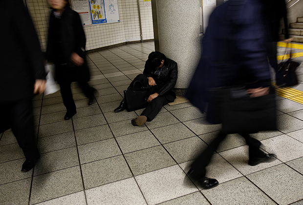 Спящий человек на станции метро в Токио