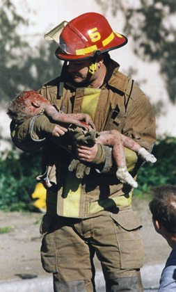 Пожарный Крис Филдс с пострадавшей при взрыве девочкой, которая позднее скончалась. Фотография стала символом теракта. За нее была присуждена Пулитцеровская премия.