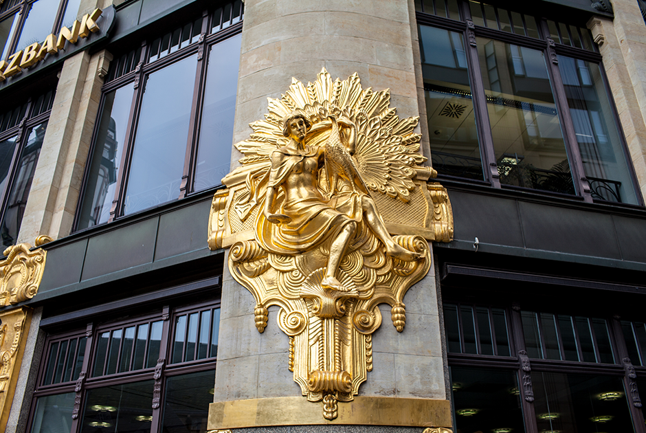 Здание банка с «золотыми» фигурами, которое было изначально построено как универмаг. На фасад несколько раз покушались желающие поживиться золотом, попытки прекратились лишь после того, как через газеты было официально объявлено, что в составе скульптур золота нет. 
