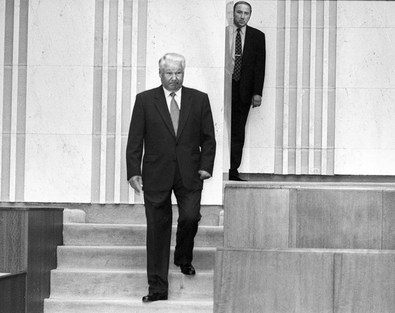 Начальник службы охраны президента Александр Коржаков наблюдает из-за кулис зала Большого Кремлевского дворца за тем, как Борис Ельцин направляется на встречу с Биллом Клинтоном.
