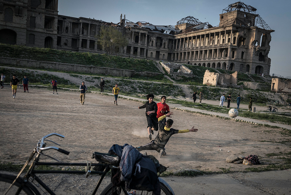Молодежь играет в футбол возле разрушенного дворца Амина. На площадке рядом — игроки в крикет, не попавшие в кадр. Пономарев отмечает, что именно крикет — любимый уличный спорт в этом регионе. 




Дворец разбомбили еще в 1979 году во время штурма советскими военными. Восстанавливать его не стали. 

