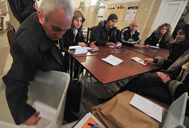 Сотрудники участковой избирательной комиссии в Ереване подсчитывают бюллетени после окончания выборов президента Армении
