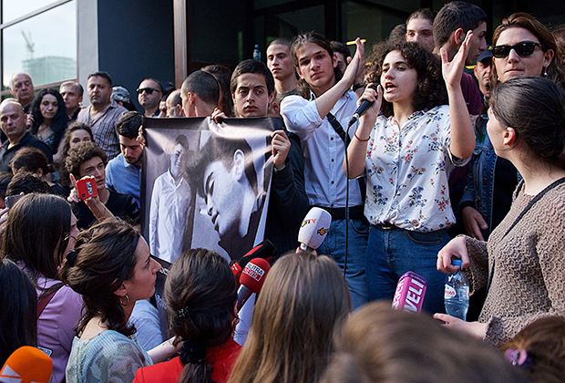 Собравшиеся у здания прокуратуры держат плакат с портретами убитых школьников