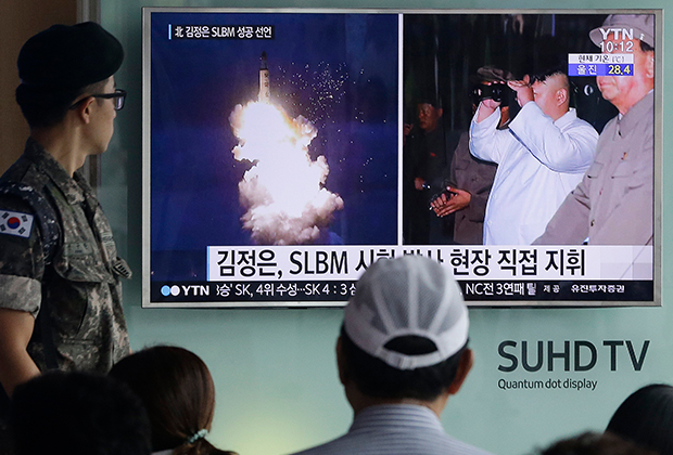 Солдат армии Южной Кореи смотрит выпуск новостей о запуске очередной северокорейской ракеты. 2016 год