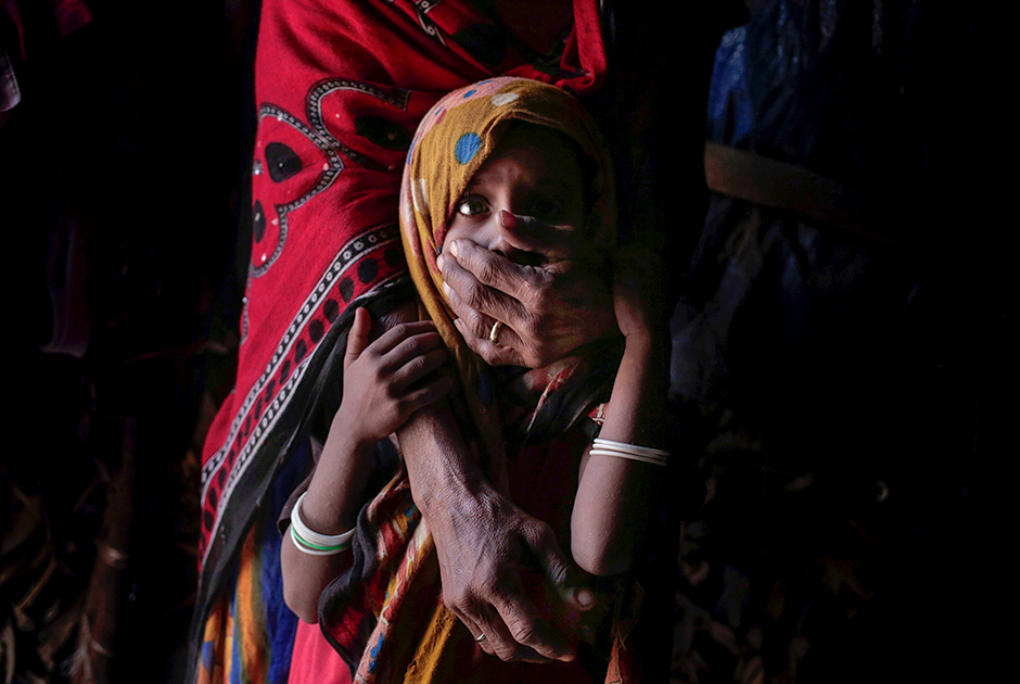 Местная жительница Хагар с пятилетней дочкой, страдающей от недоедания. Мать вынуждена кормить ее хлебом и чаем. Их семья сбежала из объятых войной регионов и осела в Адене.