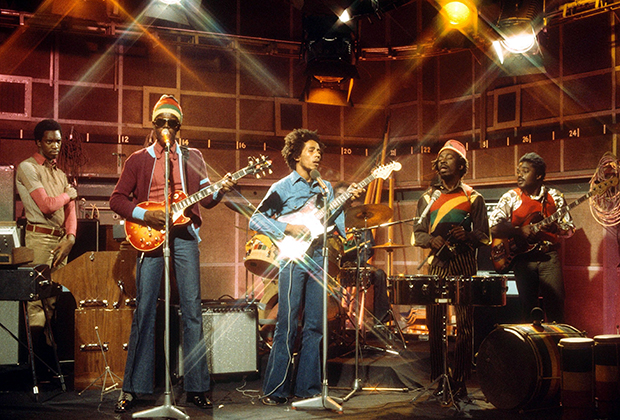 Боб Марли и The Wailers во время живого выступления на программе The Old Grey Whistle Test канала BBC в 1973 году. Питер Тош (второй слева) в своей неизменной шапочке и темных очках, Боб Марли (в центре) в клешеных джинсах и Банни Уайлер (второй справа) в панаме и футболке в раста-цветах.