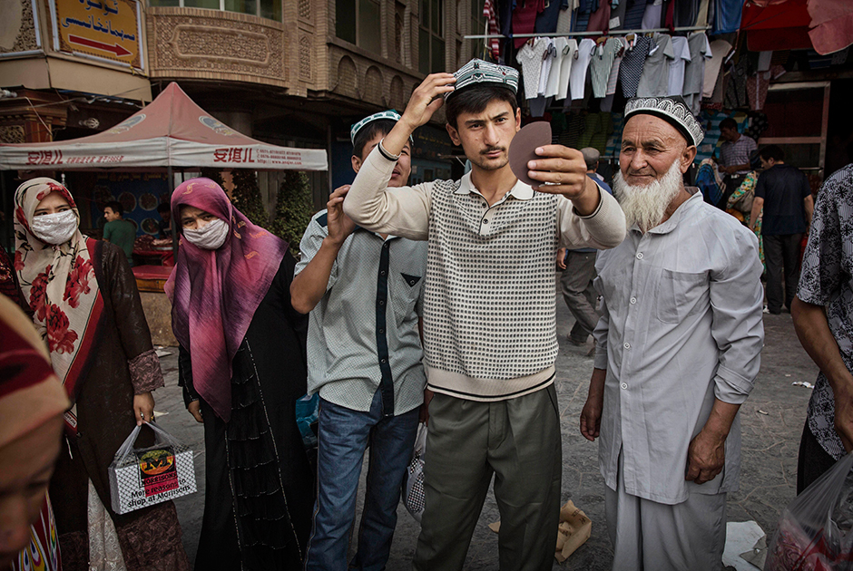 Уйгурский мужчина примеряет традиционную тюбетейку на базаре в центре Кашгара. Уйгуры составляют 81 процент населения города, а на титульный китайский этнос хань приходится лишь 18 процентов. Оставшийся один процент — дунгане, таджики, узбеки и сарыкольцы.